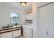 Laundry room with sink, washer and dryer, and overhead cabinets at 6335 Oberon Rd, Arvada, CO 80004