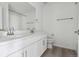 Bright bathroom featuring dual sinks, white cabinets, and modern fixtures at 25234 E Warren Pl, Aurora, CO 80018