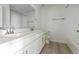Modern bathroom features double sink vanity, white cabinets, large mirror, and tile floors at 25234 E Warren Pl, Aurora, CO 80018