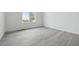 Bright, empty bedroom with wood-look floors, a large window, and freshly painted white walls at 25234 E Warren Pl, Aurora, CO 80018
