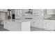A spacious, light-filled kitchen featuring a large center island, white cabinetry, and stainless steel appliances at 25234 E Warren Pl, Aurora, CO 80018