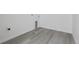 Bright laundry room space with white walls and gray wood-look vinyl flooring at 25234 E Warren Pl, Aurora, CO 80018