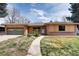 Inviting single-story home showcases a well-kept lawn, brick accents, and bright natural light at 404 S Oneida Way, Denver, CO 80224