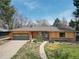 Charming single-story home featuring light wood siding, red brick accents, and a well-maintained front yard at 404 S Oneida Way, Denver, CO 80224