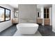 Spa-like bathroom features a freestanding tub, dual vanities, modern fixtures, and stylish gray tile at 5224 Lions Paw St, Castle Rock, CO 80104