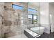 Luxurious bathroom featuring a soaking tub, glass-enclosed shower, and elegant marble tiling at 5224 Lions Paw St, Castle Rock, CO 80104