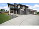 Stunning modern home showcasing a three-car garage, concrete driveway and minimalist landscaping at 5224 Lions Paw St, Castle Rock, CO 80104