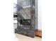 Sleek modern fireplace with dark stone and staircase featuring wood and steel accents at 5224 Lions Paw St, Castle Rock, CO 80104