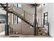 Modern staircase with metal railings and wood treads, complemented by a striking stone accent wall at 5224 Lions Paw St, Castle Rock, CO 80104