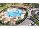 Aerial view of a sparkling community pool with lounge chairs, umbrellas, and surrounding landscaping at 17113 W 91St Ln, Arvada, CO 80007