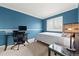 Modern bedroom with blue walls, white trim, a glass desk, and a comfortable bed with throw pillows at 1104 Fieldstone Pl, Highlands Ranch, CO 80126