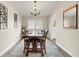 Inviting dining room with a large wooden table set for six, stylish chandelier, and decorative wall art at 1104 Fieldstone Pl, Highlands Ranch, CO 80126