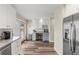 Bright kitchen featuring white cabinetry, granite countertops, stainless steel appliances, and hardwood floors at 1104 Fieldstone Pl, Highlands Ranch, CO 80126