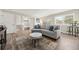 Bright living room featuring a comfortable gray couch, a large window, and neutral tones at 1104 Fieldstone Pl, Highlands Ranch, CO 80126