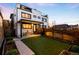 Exterior of a modern home featuring a backyard with a covered patio, artificial grass, and garden beds at 3658 Quivas St, Denver, CO 80211
