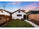 Inviting backyard features low maintenance turf, garden beds and a contemporary white house exterior at 3658 Quivas St, Denver, CO 80211