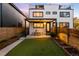 Beautiful backyard with a covered patio, artificial grass, garden beds, and privacy fence at 3658 Quivas St, Denver, CO 80211