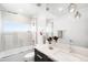 Modern bathroom with a tub and shower, sleek fixtures, and a large mirror reflecting natural light at 3658 Quivas St, Denver, CO 80211