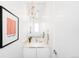 Chic powder room featuring elegant light fixture, statement art, and modern vanity at 3658 Quivas St, Denver, CO 80211