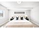 Bright bedroom features neutral walls, carpet flooring, stylish lamps, and black nightstands with modern decor at 3658 Quivas St, Denver, CO 80211