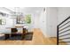 Open-concept dining area features a wooden table, bench seating, and modern light fixture at 3658 Quivas St, Denver, CO 80211