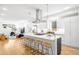 Bright eat-in kitchen features a large island with bar seating, stainless steel appliances, and hardwood floors at 3658 Quivas St, Denver, CO 80211