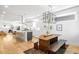 Open-concept kitchen and dining area with hardwood floors, modern lighting, and a large dining table at 3658 Quivas St, Denver, CO 80211