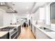 Modern kitchen with stainless steel appliances, eat-in island, white cabinets, and hardwood floors at 3658 Quivas St, Denver, CO 80211