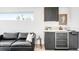 A sophisticated living area with sleek cabinets, beverage fridge and comfortable seating under a bright window at 3658 Quivas St, Denver, CO 80211
