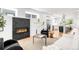 Open-concept living room and kitchen with a modern fireplace, hardwood floors, and lots of natural light at 3658 Quivas St, Denver, CO 80211