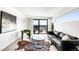 Contemporary living room featuring a black leather sofa, stylish rug, and access to an outdoor patio at 3658 Quivas St, Denver, CO 80211