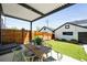 Covered outdoor patio with a dining table, artificial grass, and a privacy fence at 3658 Quivas St, Denver, CO 80211