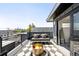 Cozy rooftop deck with lounge seating, a modern fire pit, and cityscape views beyond the railing at 3658 Quivas St, Denver, CO 80211