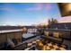 Relaxing rooftop deck showcases a stylish seating area, fire pit, and panoramic sunset views at 3658 Quivas St, Denver, CO 80211