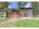 Back exterior showing a wooden deck, a grassy yard, and brown siding at 2621 S Kingston Ct, Aurora, CO 80014