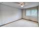 Neutral-toned bedroom featuring plush carpets, large window, and ceiling fan at 2621 S Kingston Ct, Aurora, CO 80014