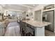 Open-concept living space with a kitchen island and stools, stainless steel refrigerator, and large windows at 10136 Yampa Ct, Commerce City, CO 80022