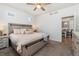 Bright main bedroom featuring a ceiling fan, a window with blinds, and views into the kitchen at 10136 Yampa Ct, Commerce City, CO 80022