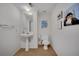 Bathroom with pedestal sink, toilet, decorative wall art, and neutral paint at 7557 S Cove Cir, Centennial, CO 80122