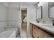 Modern bathroom featuring double vanity sinks, a large mirror, and a luxurious bathtub with marble accents at 7557 S Cove Cir, Centennial, CO 80122