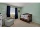 Serene Bedroom featuring a crib, cozy armchair, and soft lighting, creating a comforting space at 7557 S Cove Cir, Centennial, CO 80122