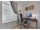 Bright home office featuring a wood desk, modern chair, and natural light from a large window at 7557 S Cove Cir, Centennial, CO 80122