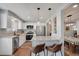 Stylish kitchen with stainless appliances, white cabinets, and breakfast bar offering modern conveniences at 7557 S Cove Cir, Centennial, CO 80122