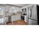Bright kitchen featuring stainless steel appliances, white cabinets, and granite countertops at 7557 S Cove Cir, Centennial, CO 80122