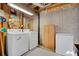 Unfinished basement laundry room with washer, dryer, storage cabinet, and freezer at 7557 S Cove Cir, Centennial, CO 80122