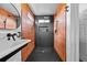 Modern bathroom featuring black floor and shower, orange tiling, and a white sink at 21005 Glacier Park Cv, Parker, CO 80138