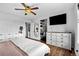 Light-filled bedroom with hardwood floors, white dresser and an adjacent workspace and closet at 21005 Glacier Park Cv, Parker, CO 80138