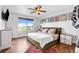Bedroom featuring a large window, ceiling fan, hardwood floors and framed wall art at 21005 Glacier Park Cv, Parker, CO 80138