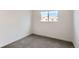 This bedroom has neutral carpet, white walls, and a window with a view of the outdoors at 7902 Chase Cir # 152, Arvada, CO 80003