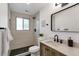 Modern bathroom featuring sleek fixtures, tiled walls, a black showerhead, and contrasting wood vanity at 10863 W 67Th Pl, Arvada, CO 80004